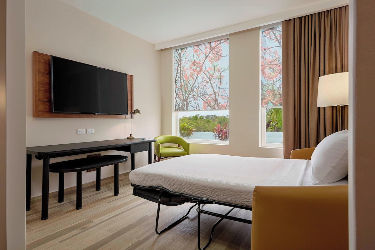 Sofá cama abierto en la suite de una recámara de Fairfield Inn & Suites Cancún Airport