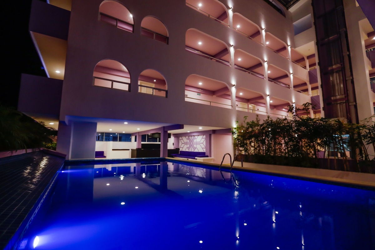 Alberca exterior con camastros en Hotel Kavia Cancún