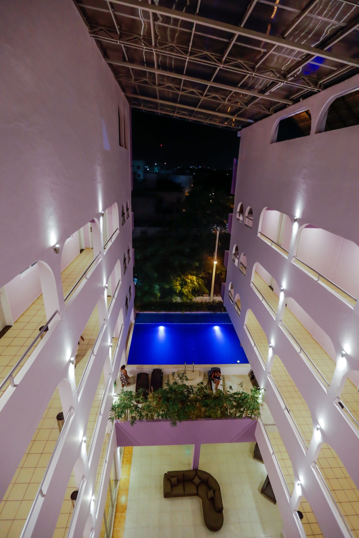 Vista nocturna hacia la alberca y los pasillos del hotel desde un piso alto de Hotel Kavia Cancún