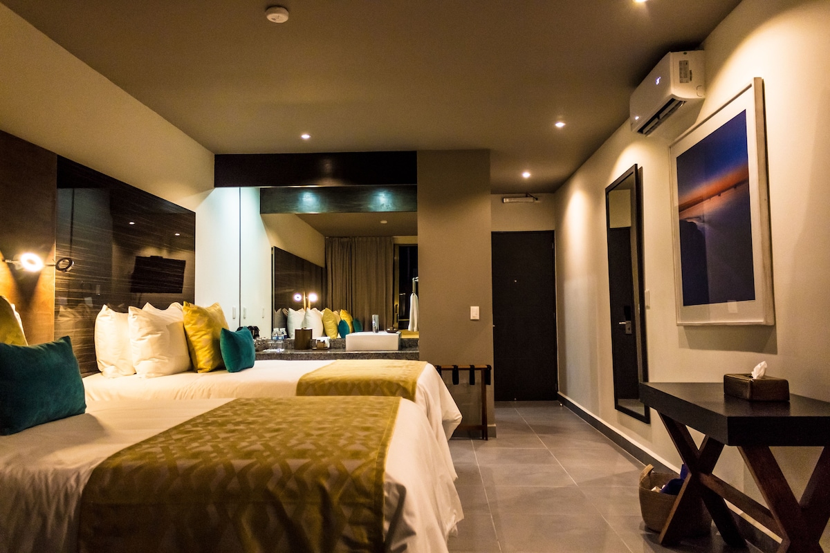 Otra vista de la Deluxe Double Room con dos camas queen en KABAH Cancún Hotel Boutique