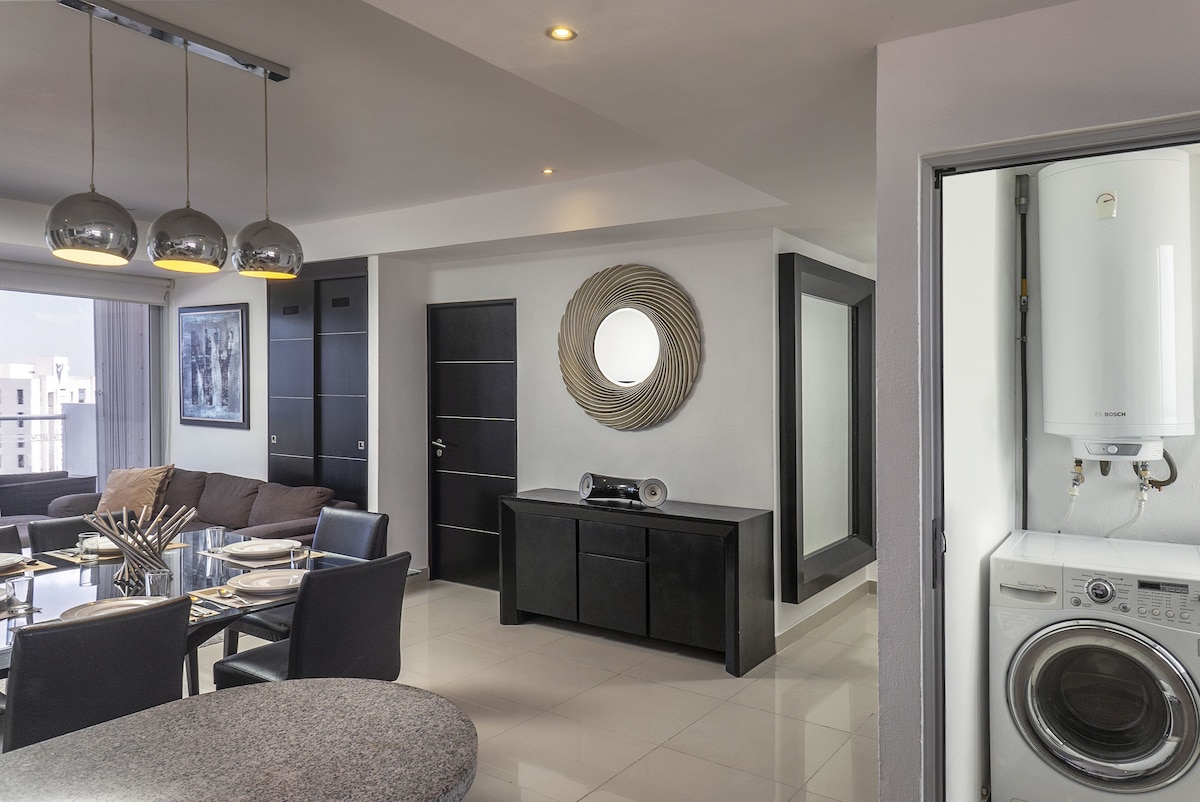Sala y comedor de la suite familiar de dos recámaras en Suites Malecón Cancún (hasta 5 personas)